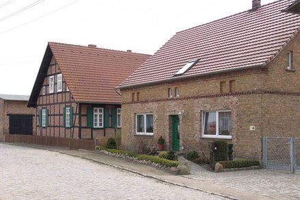 zeigt Wohnhäuser an einer Pflasterstraße