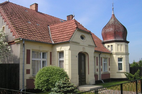 zeigt Wohngebäude mit Kuppelturm