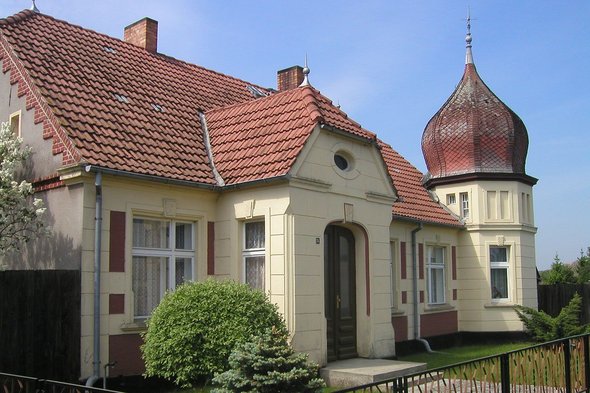 zeigt Wohngebäude mit Kuppelturm
