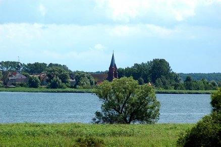 teigt Blick über das Haff auf Gebäude von Neuwarp