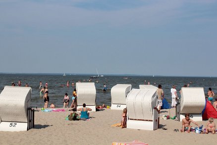 zeigt Blick auf den Strand und das Haff mit sich sonnenden und badenden Menschen