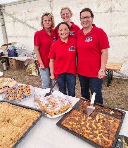 zeigt Gruppenportrait der Frauen vom Kuchenstand und ihre Kuchen