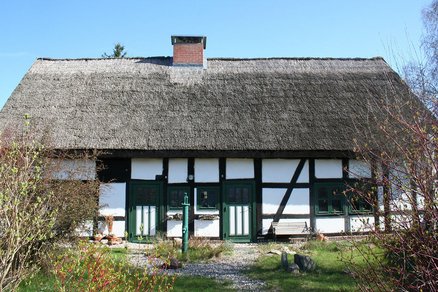 zeigt Fachwerkhaus mit Schilfdach