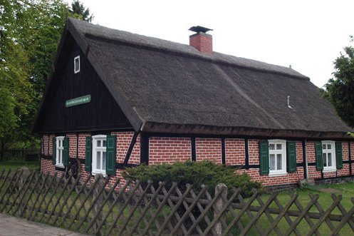 zeigt Fachwerkwohngebäude mit Schilfdach