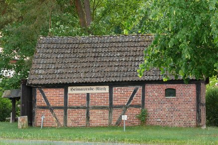 zeigt kleines Fachwerkgebäude mit Klinkermauerwerk und der Beschilderung "Heimatstube"
