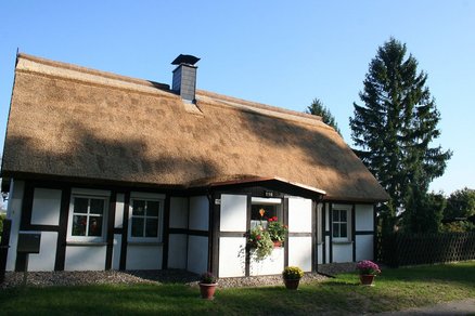 zeigt ein Wohnhaus mit Fachwerk und Schilfdach