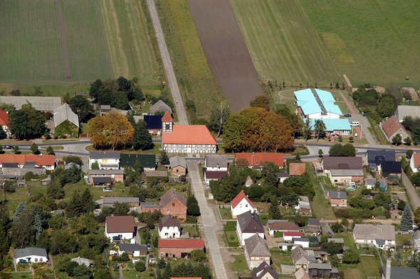 zeigt Dorfmitte mit Kirche aus der Vogelperspektive