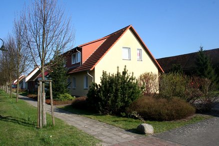 zeigt Reihe von Wohngebäuden an einem gepflasterten Gehweg