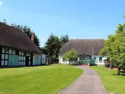 zeigt altes Bauernwohnhaus und Fachwerkscheune