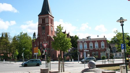 zeigt Kreuzung in der Stadtmitte von Eggesin mit angrenzender Bebauung und der Martin-Luther-Kirche