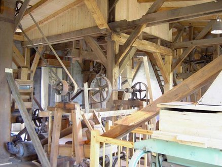 zeigt sanierte Getriebeteile im Inneren der Mühle