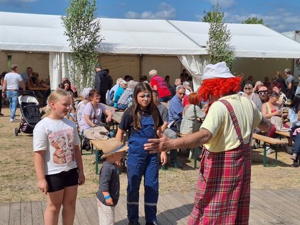 zeigt Clown mit Kindern bei seiner Darbietung