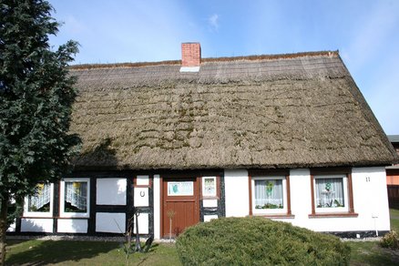 zeigt altes Fachwerkhaus mit Schilfdach