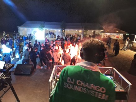 zeigt abendliche Disco mit DJ und tanzenden Leuten